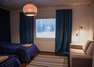 Zimmer mit einem Bett und einem Fenster mit blauen Vorhängen in der Unterkunft Talo Mustikankukka Tervola, Finland in Tervola