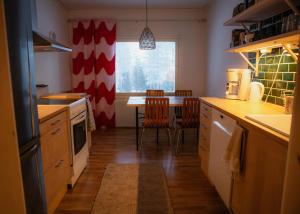 eine Küche mit Tisch und Stühlen und einem Fenster in der Unterkunft Talo Mustikankukka Tervola, Finland in Tervola