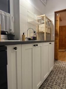 a kitchen with white cabinets and a sink at Agroturystyka Dom Wśród Sosen in Rzędkowice