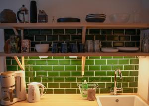 eine Küche mit grünen gefliesten Wänden und einem Waschbecken in der Unterkunft Talo Mustikankukka Tervola, Finland in Tervola