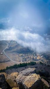 a view from the top of a mountain with clouds at Dana Star lodge in Dana