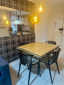 einen Tisch und Stühle in einer Küche mit Beleuchtung in der Unterkunft ilha confort, aconchegante ideal para casal, famílias e amigos in São Luís