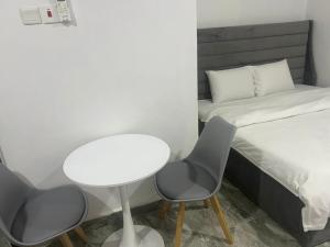 a small room with a bed and a table and chairs at Spacious Studio in Asokoro in Aso