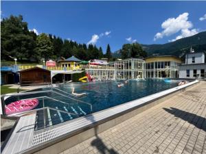 a large swimming pool with people in the water at Villa Sonnenpiste in Kötschach