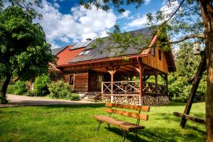 a wooden house with a bench in front of it at Zagroda Magija Bieszczady in Orelec