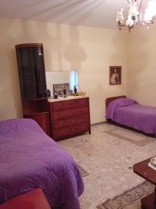 a bedroom with two beds and a dresser and a mirror at "La Casa sul fiume" in Marsico Nuovo