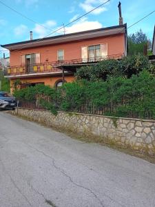 a large orange house with a stone wall at "La Casa sul fiume" in Marsico Nuovo
