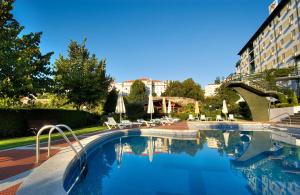 une piscine avec des chaises et un hôtel dans l'établissement Hotel Eurosol Seia Camelo, à Seia