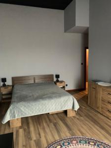 a bedroom with a large bed and wooden floors at Bulwar Apartament Stare Miasto in Głogów