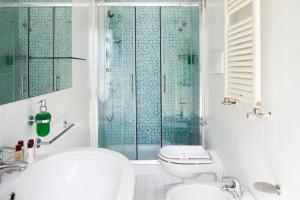 a bathroom with a shower and a toilet and a sink at Hotel Ambassador in Rimini