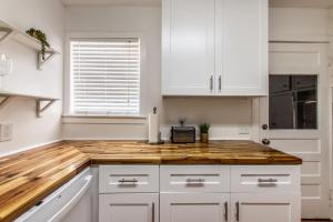 een keuken met witte kasten en een houten aanrechtblad bij Texas Tranquility Retreat in Corpus Christi