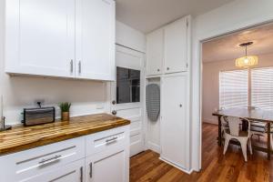 een keuken met witte kasten en een tafel met een magnetron bij Texas Tranquility Retreat in Corpus Christi +17 foto's