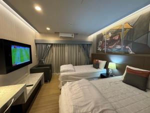 a hotel room with two beds and a flat screen tv at Cha-am , Cityscape Comfort , Near Cha-am Beach South in Cha Am