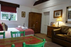 a bedroom with a bed and a table and a couch at Home Farm & Lodge in Bawtry