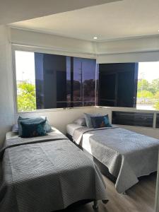 a bedroom with two beds and a large window at Apto Vip acceso a la playa in El Morro de Barcelona