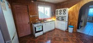 a kitchen with a stove and white cabinets and a door at Casa Castro Villa in Castro