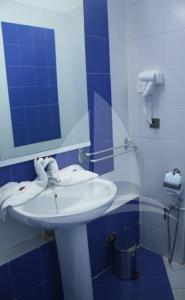a bathroom with a sink and a mirror at Marina Cap Monastir- Appart'Hôtel in Monastir