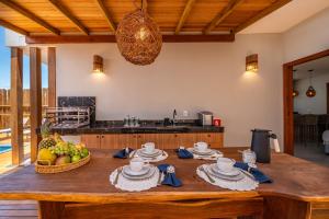 a kitchen with a wooden table with a bowl of fruit at Bahia Soul - Casa Ayla - Barra Grande - Península de Maraú in Marau +181 photos