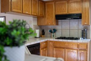 a kitchen with wooden cabinets and a stove top oven at Heaven Heights - HotTub, Pet Friendly, EV Outlet, Pool Table, Game Room, BBQ, FirePit, Library in Oakhurst +35 photos