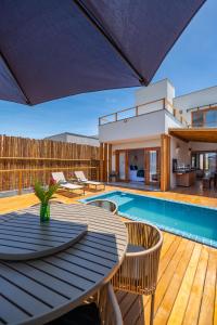 a patio with a table and chairs and a swimming pool at Bahia Soul - Casa Ayla - Barra Grande - Península de Maraú in Marau