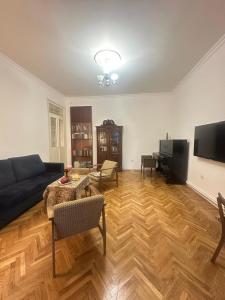 a living room with a couch and a television at Retro style apt You rent a whole apartment in the center of Yerevan in Yerevan