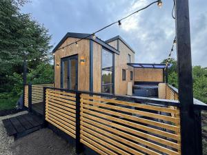 a tiny house on the side of a fence at Fiadh Rua Cabin - with Private Outdoor Hottub Pet Friendly in Kinlough