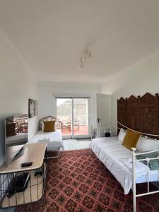 a bedroom with two beds and a desk in it at Lala Panzi - Grotto Beach, Voëlklip in Hermanus +8 photos