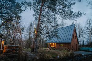 a barn with a green roof in the woods at Chata Szyszka in Męcina Mała