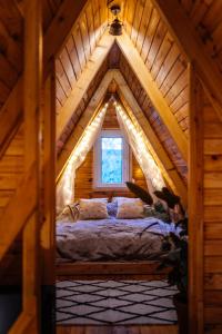 a bedroom in a log cabin with a large window at Chata Szyszka in Męcina Mała