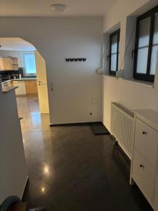 une pièce vide avec une cuisine et un couloir dans l'établissement Ferienwohnung, Tageswohnung neben Braunschweig, à Meine
