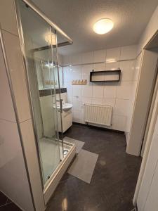 une salle de bain avec une douche en verre et un lavabo dans l'établissement Ferienwohnung, Tageswohnung neben Braunschweig, à Meine