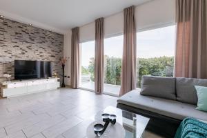 a living room with a couch and a tv at Holiday house Martinović in Prigradica