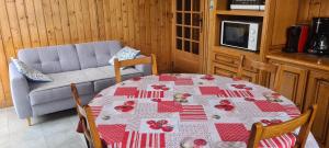 a dining room table with a red and white table cloth at Maison au coeur du Jura - 4 chambres - 9 couchages in Champagnole
