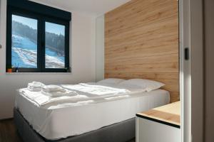 a bedroom with a large white bed with a window at Apartman Fića, Ravna Planina in Pale