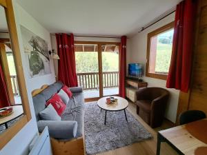 a living room with a couch and a table at Le Corbier, T3, 4-6 pers in Villarembert