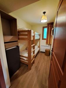 a room with three bunk beds and a refrigerator at Le Corbier, T3, 4-6 pers in Villarembert