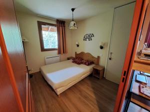 a small bedroom with a bed and a window at Le Corbier, T3, 4-6 pers in Villarembert