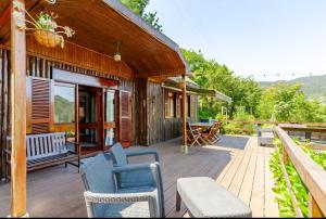 eine Holzterrasse mit Stühlen und ein Haus in der Unterkunft Casa Soutinho - Gerês in Ventosa