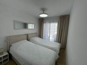 a bedroom with two beds and a window at Apartament Premium Hipocampos in Ifach +9 photos