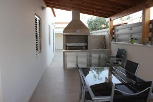 a kitchen with a glass table and chairs and a stove at Modern spotless house with full privacy and WiFi in Aglantzia Nicosia in Aglantzia