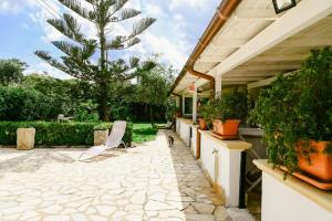 a patio with a chair and potted plants at Appartamenti Frassanito in Conca Specchiulla