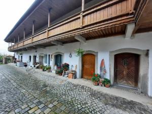 a white building with wooden doors and potted plants at Am Kapferhof in Hauzenberg