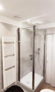 une douche avec une porte en verre dans une salle de bain dans l'établissement Maison 4Emme, à La Thuile