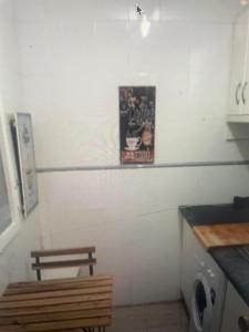a kitchen with a sign on the wall and a washing machine at Sebastian Elcano, Metro Embajadores, centro de Madrid in Madrid