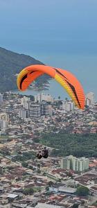 a person flying a parachute over a city at Posada Verde Balneario Caragua in Caraguatatuba