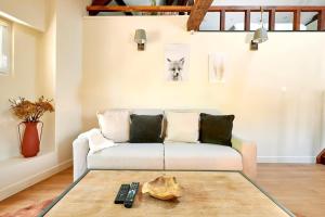 a living room with a couch and a remote control at Versailles One Sauna & Jacuzzi in Versailles