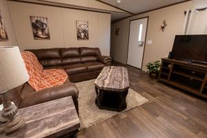 a living room with leather furniture and a flat screen tv at Winding Way Retreat-Georgetown in Georgetown