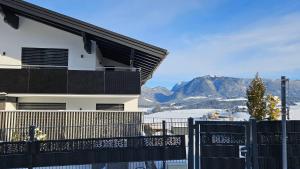 a house with a fence and mountains in the background at Appartment Haus Einbergblick in Abtenau