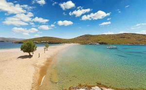 a sandy beach with a boat in the water at Mirsinia Room in Mérikhas