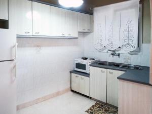 a white kitchen with a sink and a microwave at Mirsinia Room in Mérikhas +16 photos